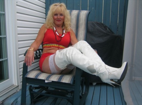 Aged blonde amateur Ruth goes topless in a mirror while wearing stripper boots