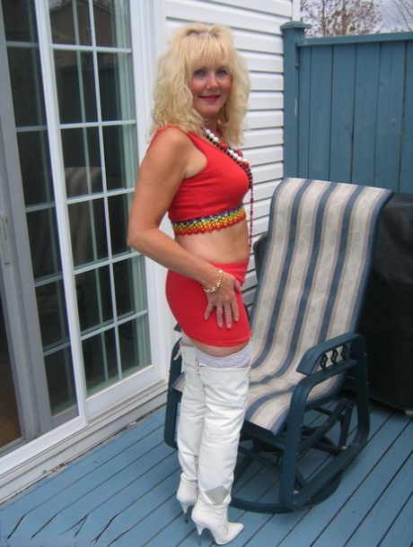 Aged blonde amateur Ruth goes topless in a mirror while wearing stripper boots