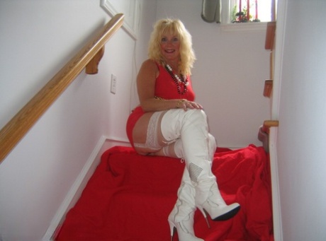 Aged blonde amateur Ruth goes topless in a mirror while wearing stripper boots