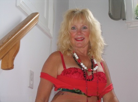 Aged blonde amateur Ruth goes topless in a mirror while wearing stripper boots
