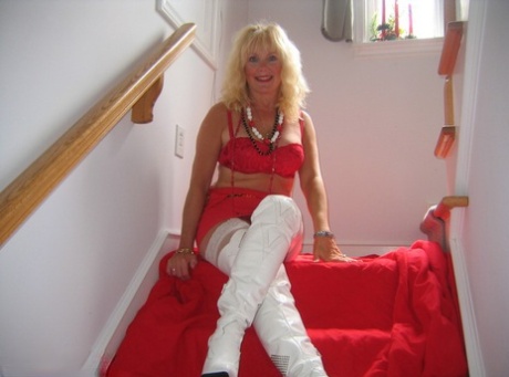 Aged blonde amateur Ruth goes topless in a mirror while wearing stripper boots