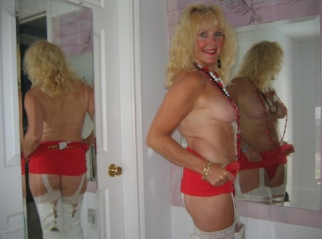 Aged blonde amateur Ruth goes topless in a mirror while wearing stripper boots