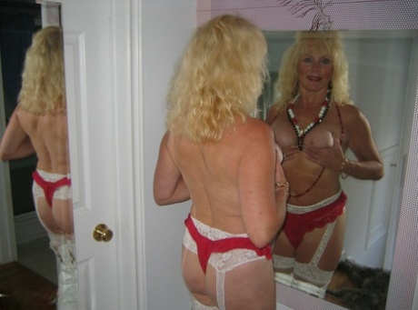 Aged blonde amateur Ruth goes topless in a mirror while wearing stripper boots