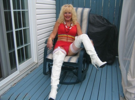 Aged blonde amateur Ruth goes topless in a mirror while wearing stripper boots