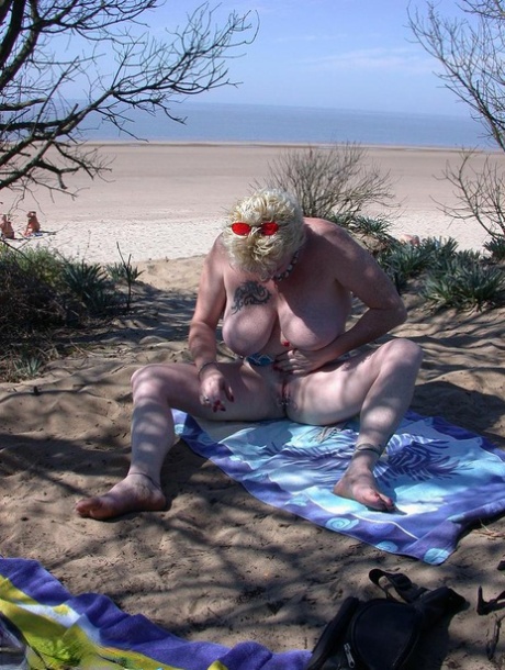Older blonde amateur Mary Bitch takes a pee before going topless in the ocean