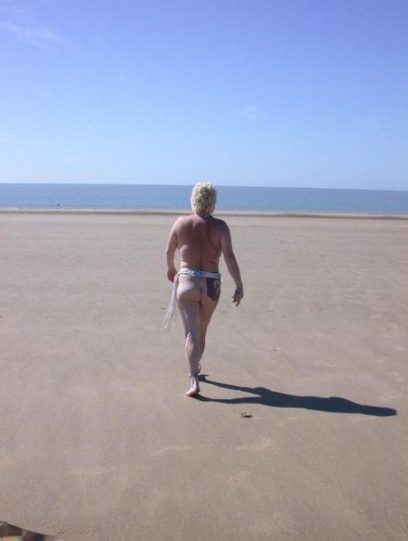Older blonde amateur Mary Bitch takes a pee before going topless in the ocean