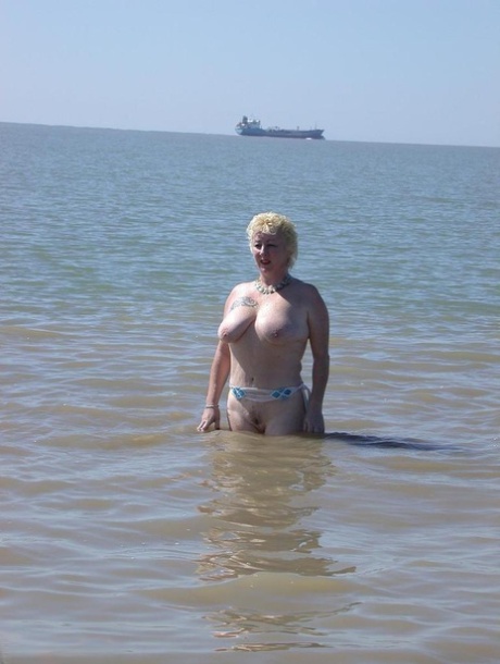 Older blonde amateur Mary Bitch takes a pee before going topless in the ocean