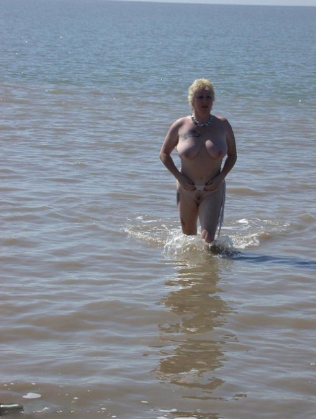 Older blonde amateur Mary Bitch takes a pee before going topless in the ocean