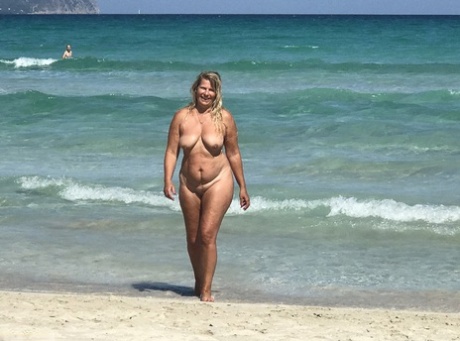 Fat mature woman Sweet Susi hangs out at the beach in the nude