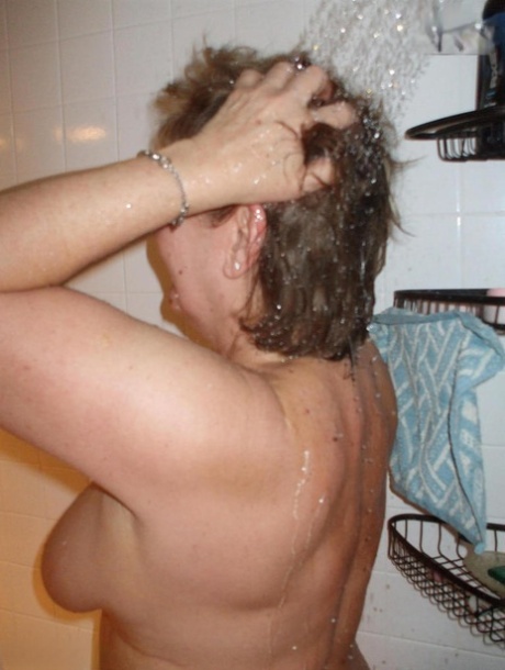 Mature lady Busty Bliss takes a cock in hand while showering at the same time