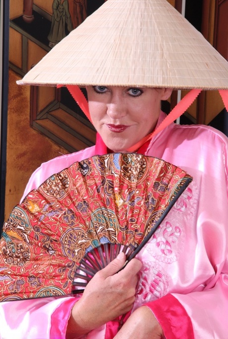 Mature woman Shauna strips to black pumps afore an Oriental screen