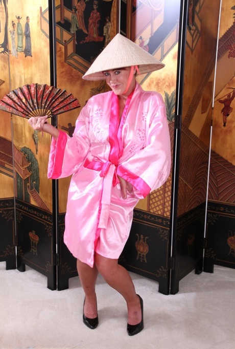 Mature woman Shauna strips to black pumps afore an Oriental screen