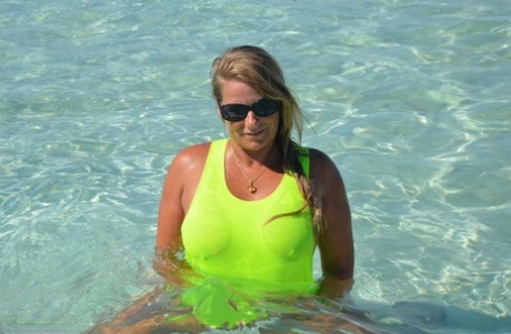 Middle-aged blonde Sweet Susi exposes her ass and pussy while in the ocean