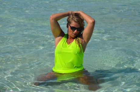 Middle-aged blonde Sweet Susi exposes her ass and pussy while in the ocean
