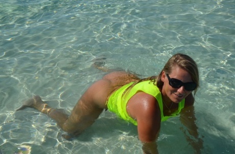 Middle-aged blonde Sweet Susi exposes her ass and pussy while in the ocean