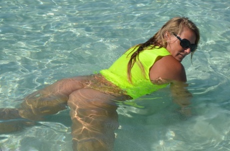 Middle-aged blonde Sweet Susi exposes her ass and pussy while in the ocean
