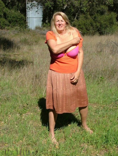 Old amateur Adonna bares her big tits and bald cunt with the sun in her eyes
