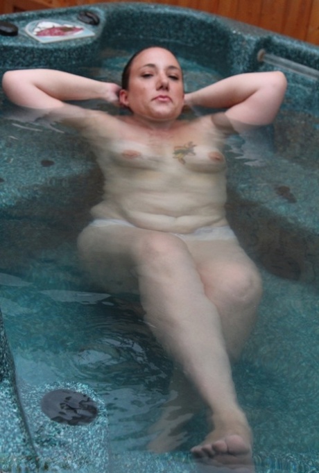 Mature redhead displays her plump body while naked in an outdoor hot tub