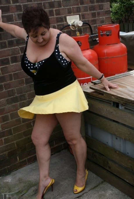 Fat older woman Kinky Carol flashes her bra and upskirt underwear on a patio