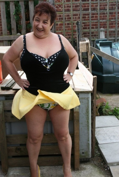Fat older woman Kinky Carol flashes her bra and upskirt underwear on a patio