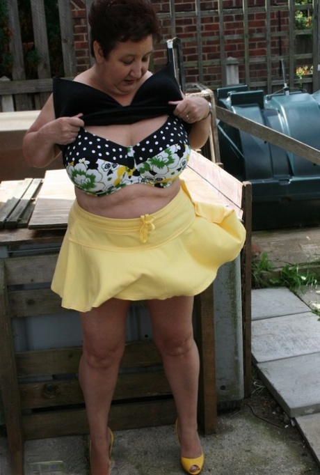Fat older woman Kinky Carol flashes her bra and upskirt underwear on a patio