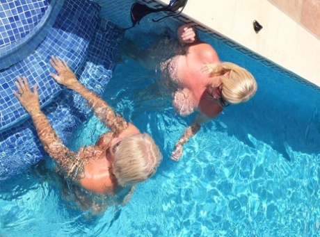 Mature woman Melody receives cunnilingus from a lesbian in a swimming pool