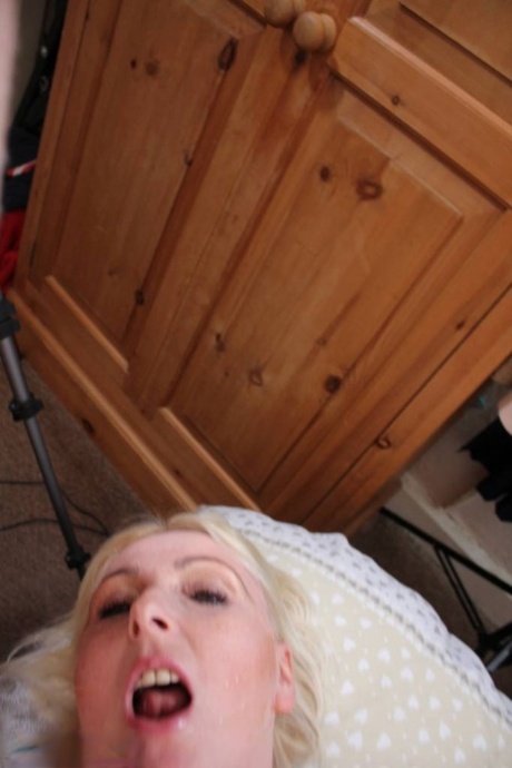 Blonde British woman Tracey Lain receives an open mouth cumshot after anal sex