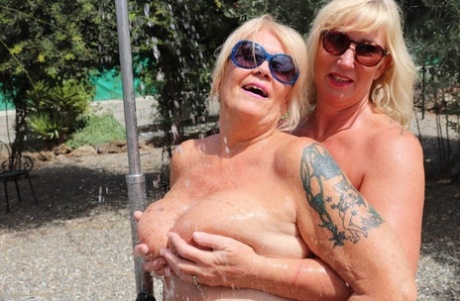 Fat blonde lady Melody and her lesbian lover shower together in the outdoors