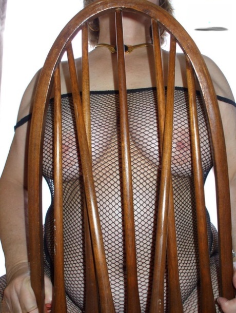 Chubby older lady Busty Bliss sports glasses while wearing a mesh bodystocking