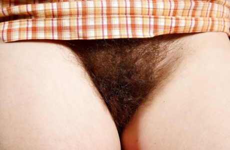 Mature brunette Sunshine spreads her legs to reveal hairy bush