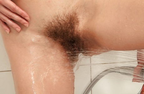 Mature brunette woman undressing for hairy pussy masturbation in shower