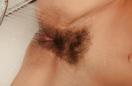 Mature brunette woman undressing for hairy pussy masturbation in shower