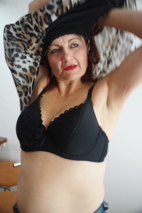 Mature redhead Justina Sindell strips and touches her fat hairy snatch