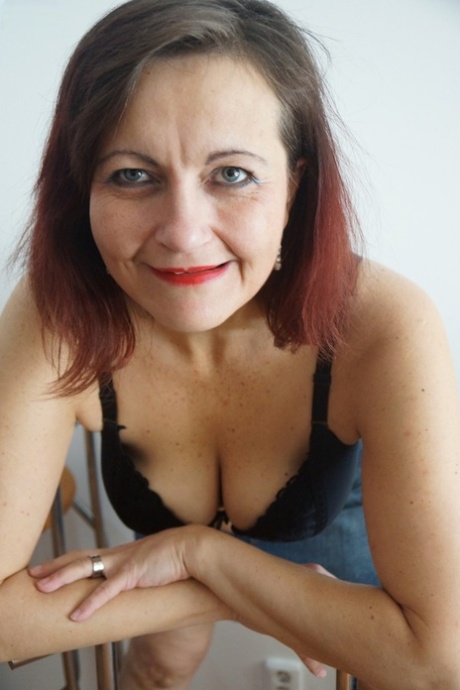 Mature redhead Justina Sindell strips and touches her fat hairy snatch