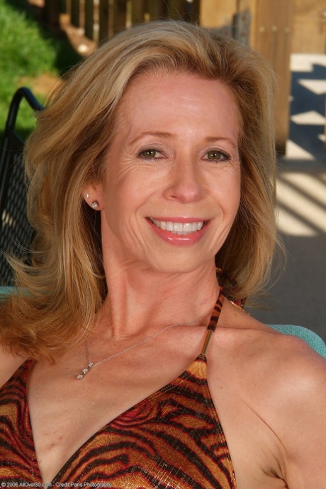 Mature woman Marie-Kelly does a sexy striptease in a bikini outdoors