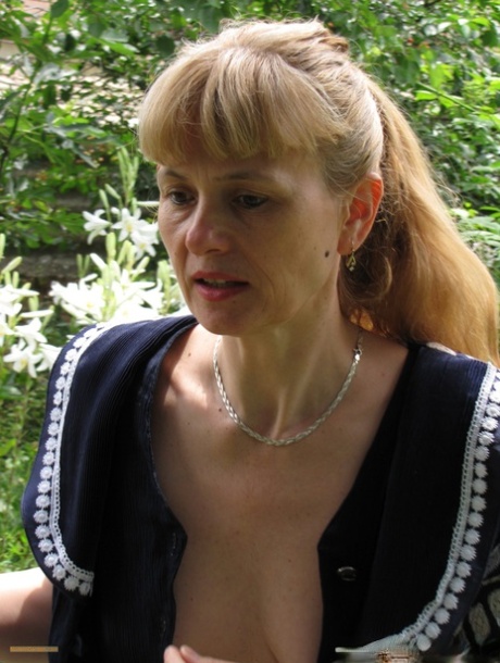 Sexy mature amateur Doris Dawn unveils her cute boobs and poses naked outdoors