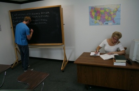 Short-haired teacher Tracy Lick milks a shy student's large dick during class