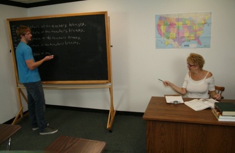 Short-haired teacher Tracy Lick milks a shy student's large dick during class