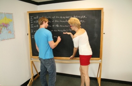 Short-haired teacher Tracy Lick milks a shy student's large dick during class
