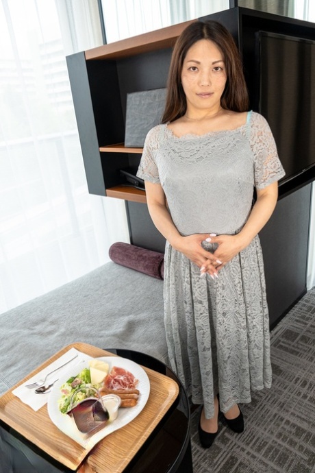 Cute MILF Midori Minami strips naked and poses enticingly in a hotel room