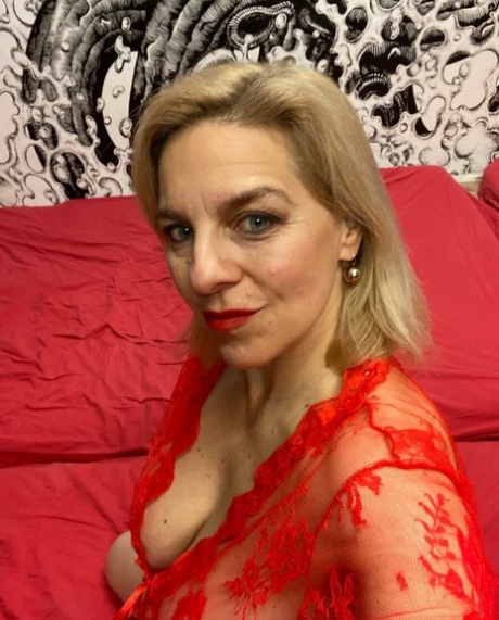 Glamorous cougar teases with her sexy cleavage while posing in her lingerie