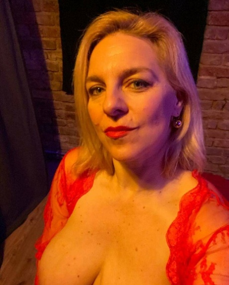 Glamorous cougar teases with her sexy cleavage while posing in her lingerie