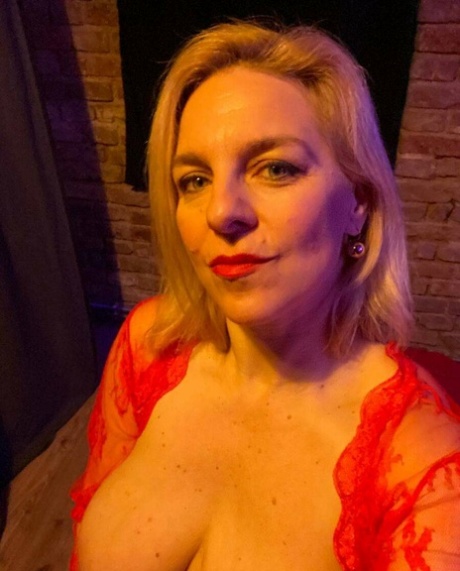Glamorous cougar teases with her sexy cleavage while posing in her lingerie