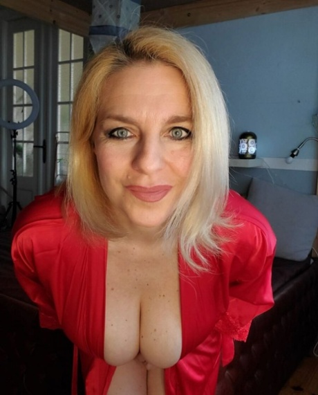 Glamorous cougar teases with her sexy cleavage while posing in her lingerie