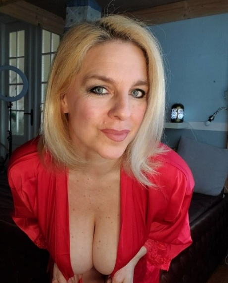 Glamorous cougar teases with her sexy cleavage while posing in her lingerie